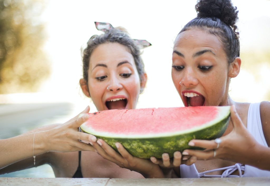 two women sharing a large watermelon